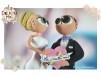 Figurine de tort pentru nunta - Mirii tin in mana o inimioara roz pe care scrie "La multi ani"
